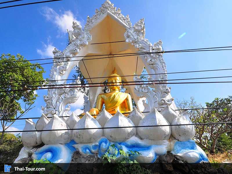 พระพุทธรูปปูปั้นสีทอง ด้านหน้าริมถนน