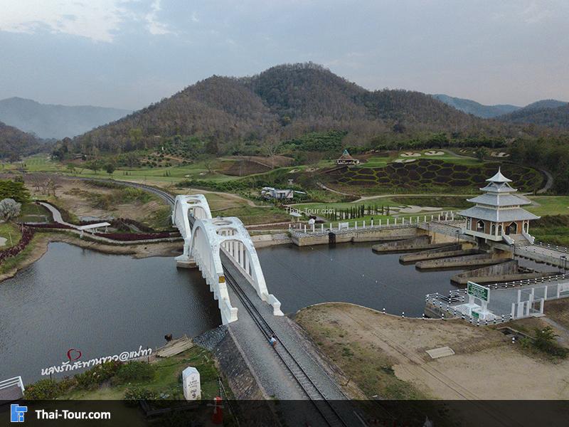 ภาพมุมสูง ของสะพานขาวทาชมภู มองเห็นวิวด้านหลังเป็นภูเขา